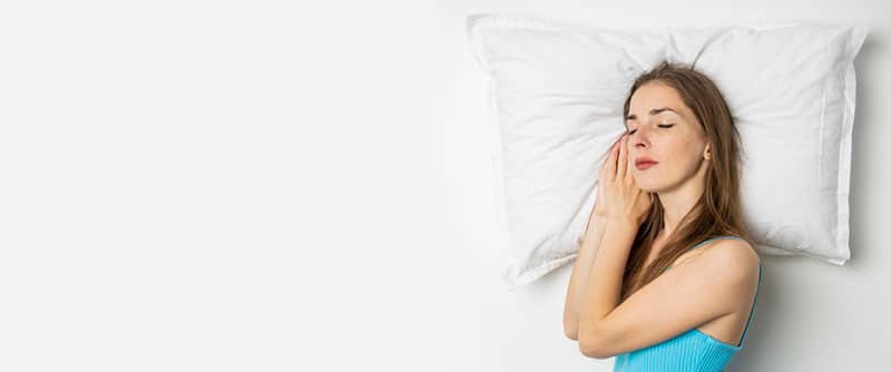 sleeping young woman lying on bed