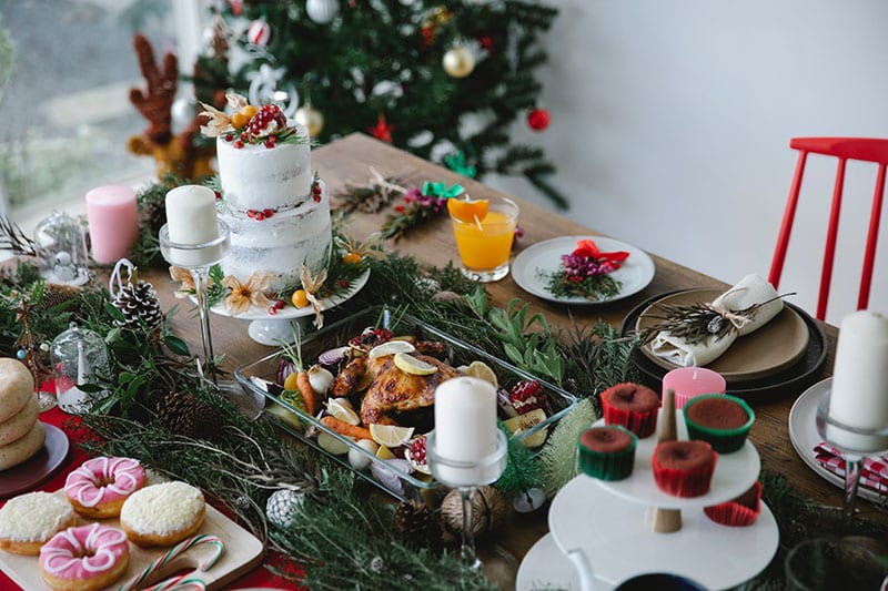 table full of chicken, vegetables and yummy desserts